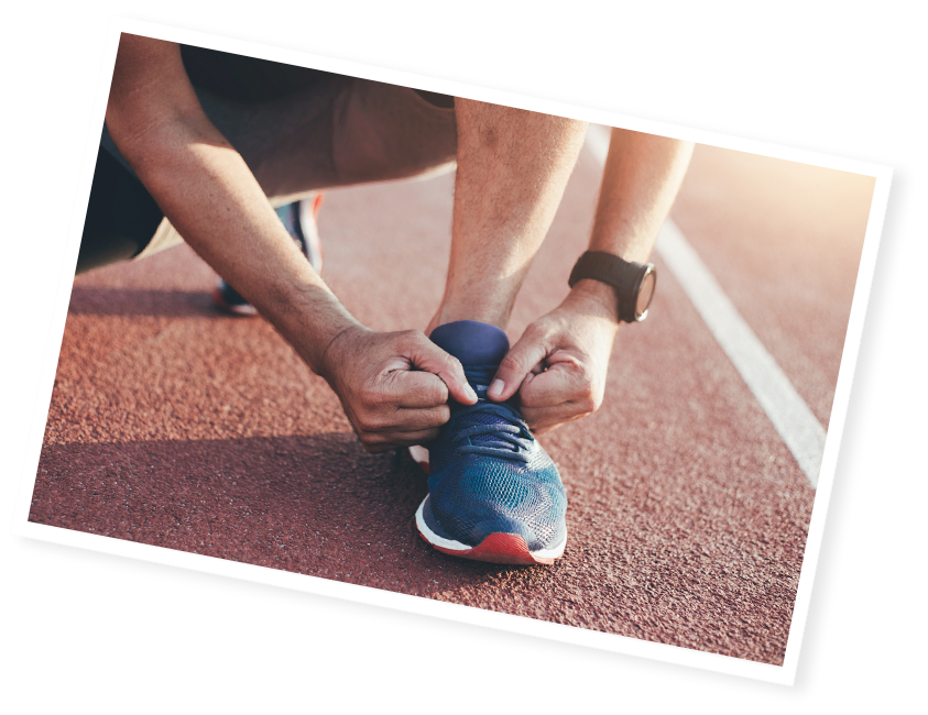 un sportif qui attache ses chaussures de running sur une piste d’athlétisme.